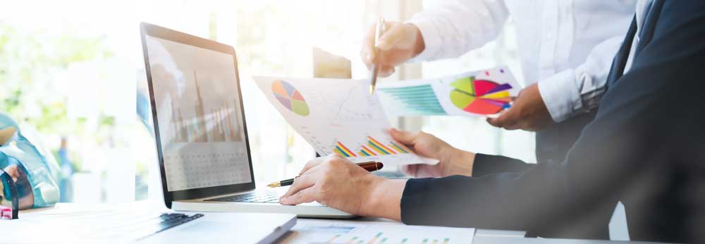 Employees holding up a document with employee performance charts