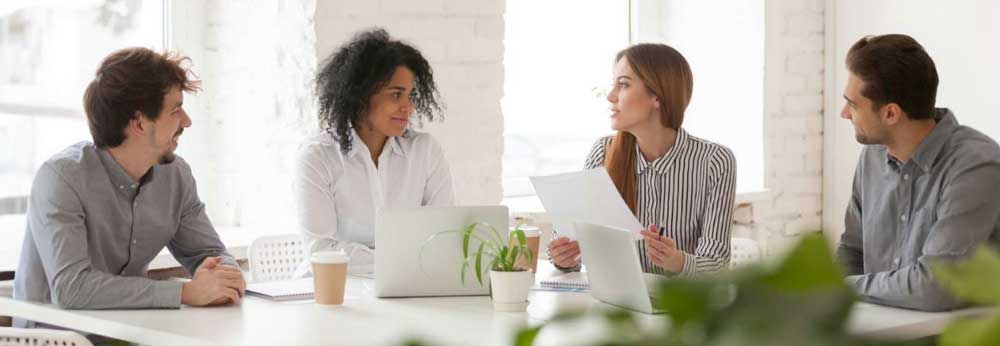 Employees sitting on a table together engaging in discussion