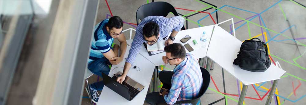 Group of employees gathered around a laptop