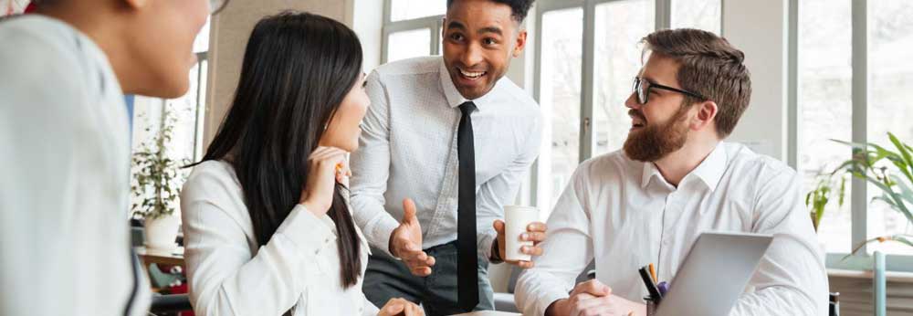 Employees engaging in discussion over a laptop