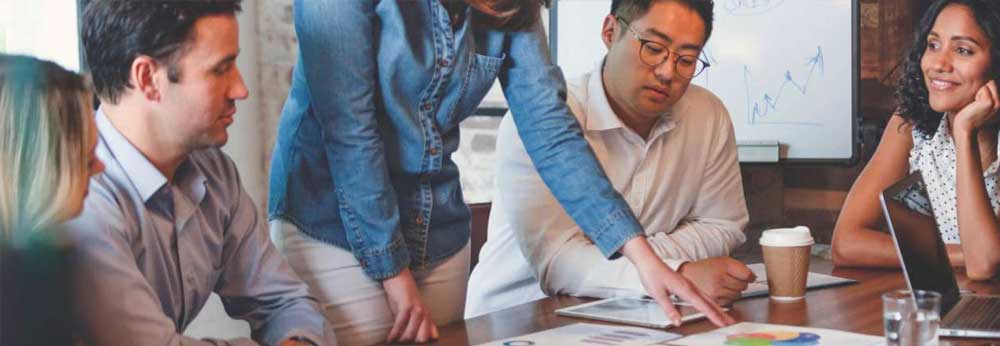 Group of employees looking at data chart around a table