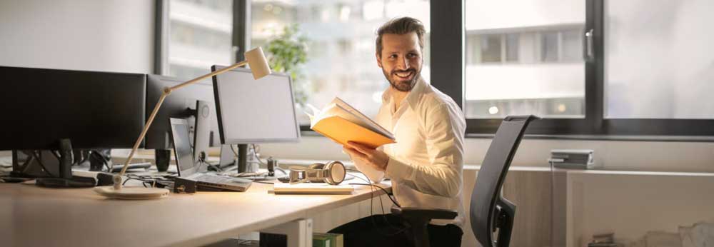 Employee sitting in from of his desk with laptop turned off