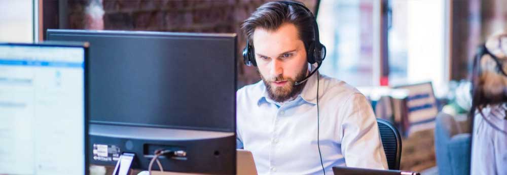 Employee wearing a headset working on his computer