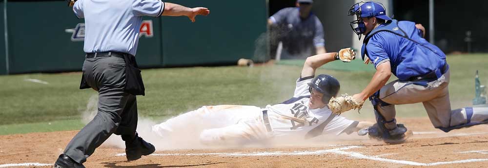 Baseball player sliding to home base as catcher tags him